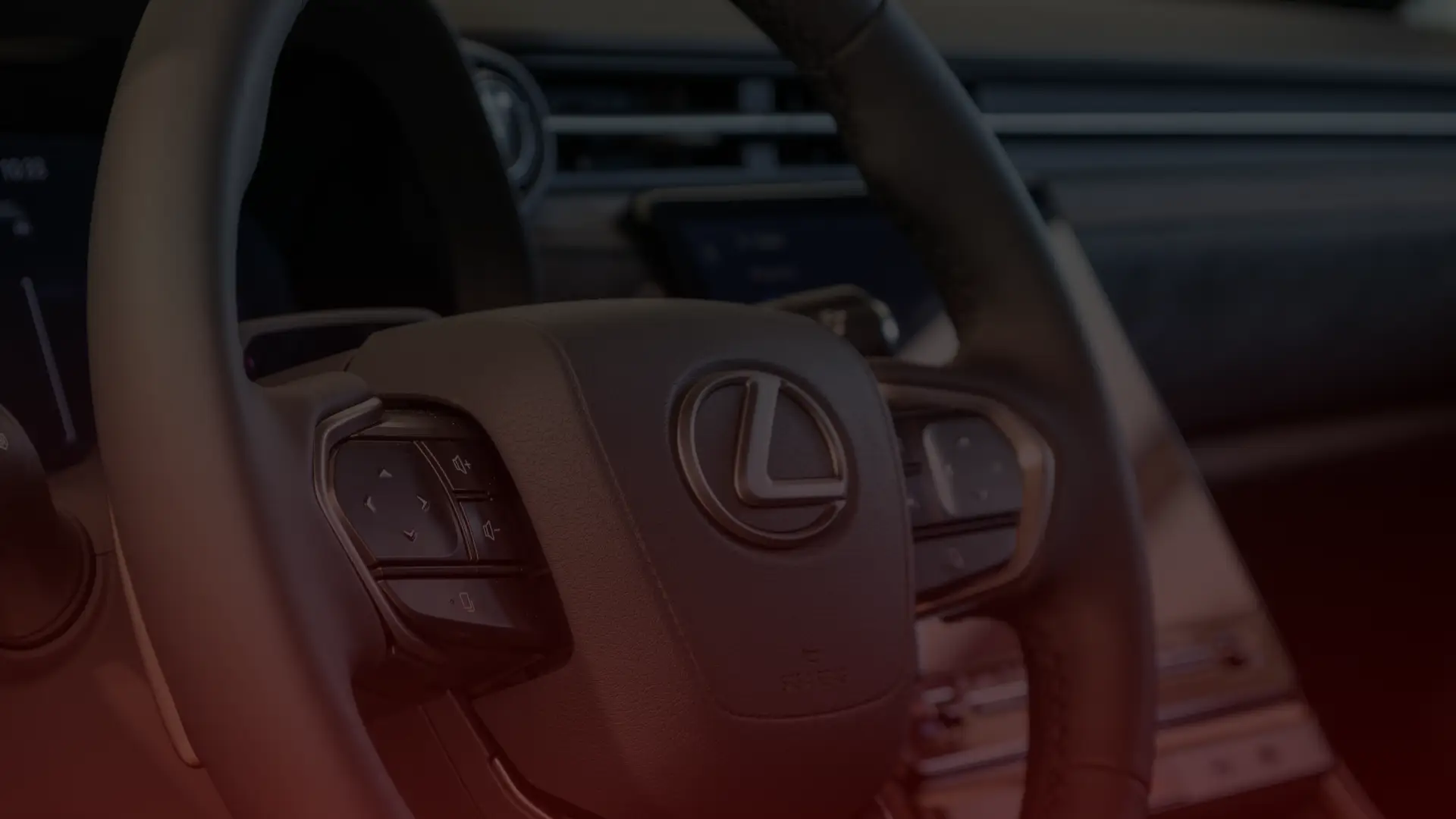 Close-up view of a Lexus steering wheel, with the brands logo at the center. The interior boasts black leather and visible control buttons, hinting at precision akin to an Acura mechanics craftsmanship in Greater Toronto and Guelph, with a dashboard glimpse in the background. EuroMechanic | Top Reviewed Auto Repair Shop | Greater Toronto and Guelph | Visit Euromechanic