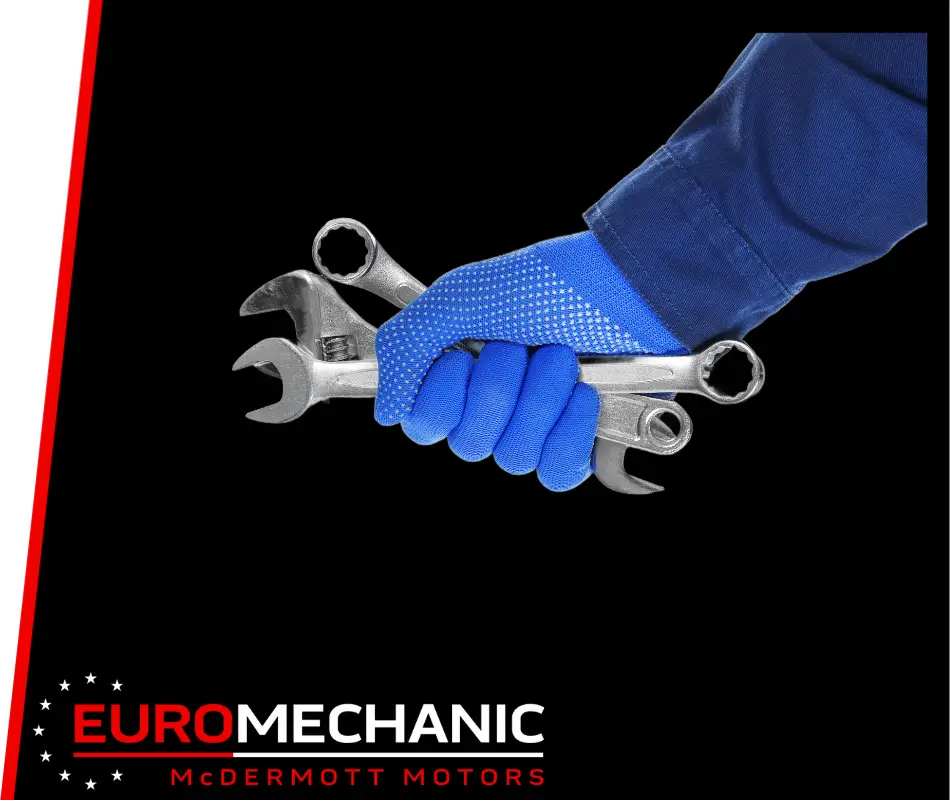 A hand in a blue glove holds several silver wrenches against a black background, symbolizing expert car repair. The bottom left corner features the Euromechanic McDermott Motors logo in red and white text, highlighting their dedication to preventative maintenance across Greater Toronto and Guelph. EuroMechanic | Top Reviewed Auto Repair Shop | Greater Toronto and Guelph | Visit Euromechanic