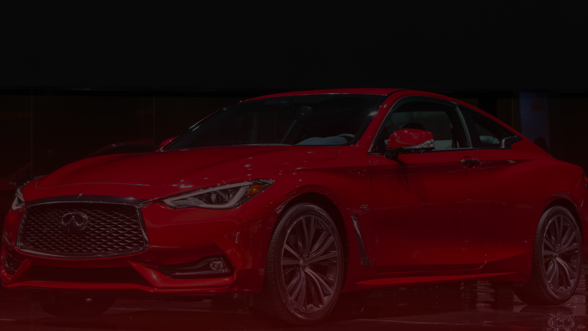 A sleek, red sports coupe is displayed against a dark background. The car, possibly serviced by a skilled Toyota mechanic in Greater Toronto, boasts a shiny exterior, angular headlights, and a prominent front grille, exuding a modern and luxurious appearance. EuroMechanic | Top Reviewed Auto Repair Shop | Greater Toronto and Guelph | Visit Euromechanic
