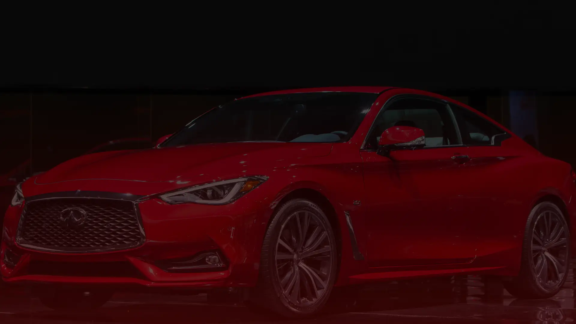 A sleek, red sports coupe is displayed against a dark background. The car, possibly serviced by a skilled Toyota mechanic in Greater Toronto, boasts a shiny exterior, angular headlights, and a prominent front grille, exuding a modern and luxurious appearance. EuroMechanic | Top Reviewed Auto Repair Shop | Greater Toronto and Guelph | Visit Euromechanic