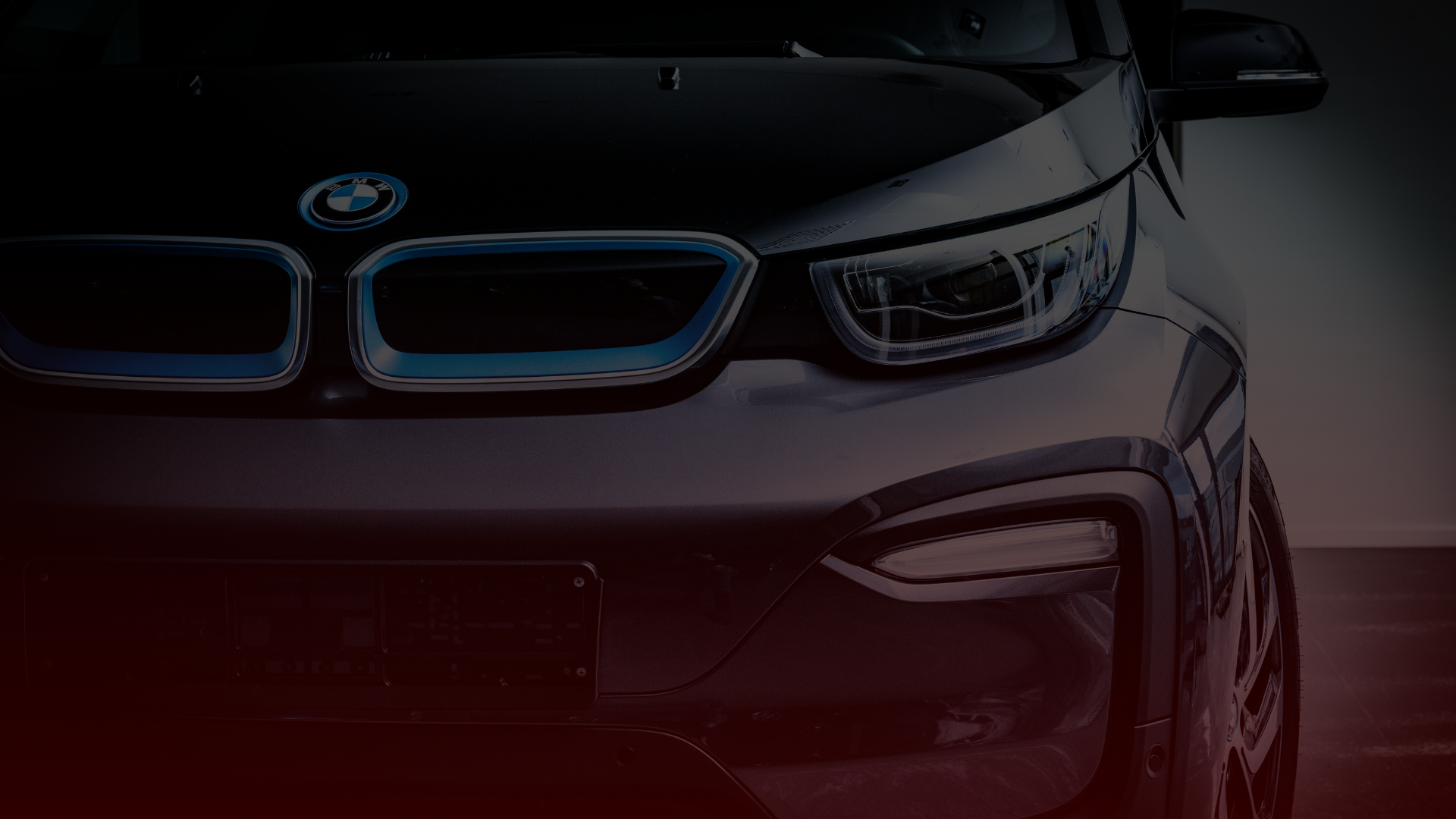 Close-up of a BMW car front, focused on the right headlight and part of the grille. The metallic finish reflects light, highlighting the BMW emblem. Serviced by expert mechanics in Greater Toronto and Guelph, its sleek design stands out against the dark background. EuroMechanic | Top Reviewed Auto Repair Shop | Greater Toronto and Guelph | Visit Euromechanic