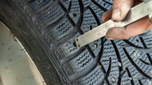 EuroMechanic technician checking winter tire age, tread depth and condition before seasonal installation in Ontario